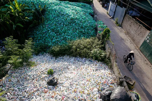 A Vietnamese woman cycles past recyclable plastic bottles at Xa Cau village, outside Hanoi, Vietnam June 5, 2018. (Photo by Reuters/Kham)