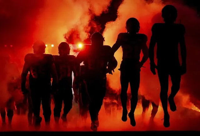 B.C. Lions players are silhouetted as they run onto the field for a Canadian Football League game against the Winnipeg Blue Bombers on Friday, October 6, 2023, in Vancouver, British Columbia. (Photo by Darryl Dyck/The Canadian Press via AP Photo)