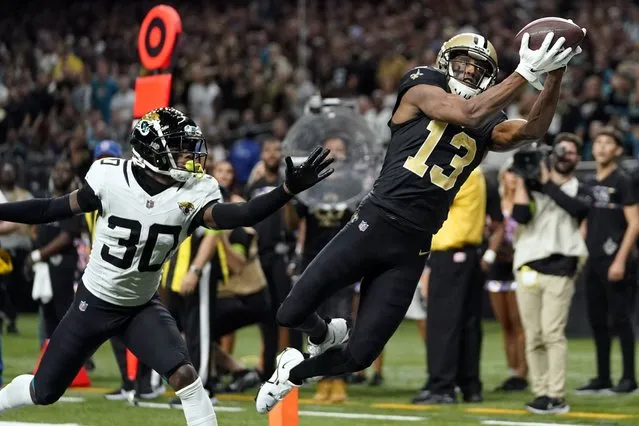 New Orleans Saints wide receiver Michael Thomas (13) makes a catch for a touchdown in front of Jacksonville Jaguars cornerback Montaric Brown (30) in the second half of an NFL football game in New Orleans, Thursday, October 19, 2023. (Photo by Gerald Herbert/AP Photo)