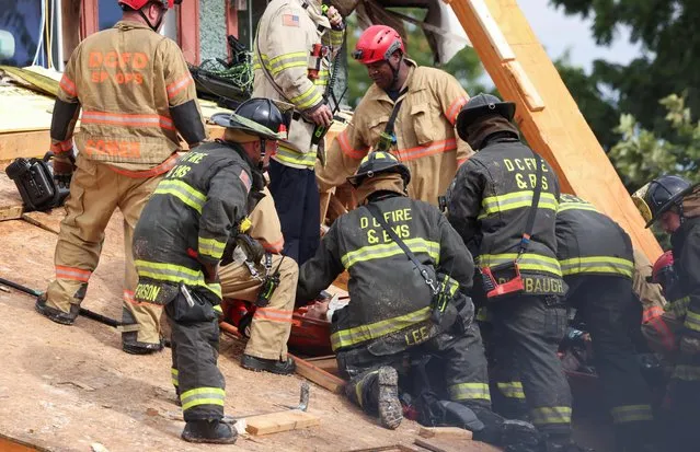 Emergency personnel prepare to transport a man on a stretcher after he was extricated from the debris after a building undergoing construction collapsed in Washington, U.S., July 1, 2021. (Photo by Evelyn Hockstein/Reuters)