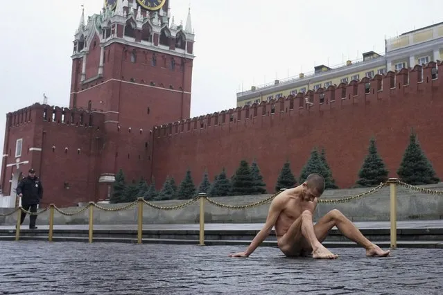 Artist Pyotr Pavlensky sits in the Red Square during a protest in front of the Kremlin wall in Moscow, on November 10, 2013. He nailed himself to the pavestones by his genitals in protest of what he sees as apathy in contemporary Russian society. The Saint Petersburg-based artist said in a statement posted on the Grani.ru website that he was trying to draw attention to Russian society's inaction in the face of the development of a “police state”. (Photo by Maxim Zmeyev/Reuters)