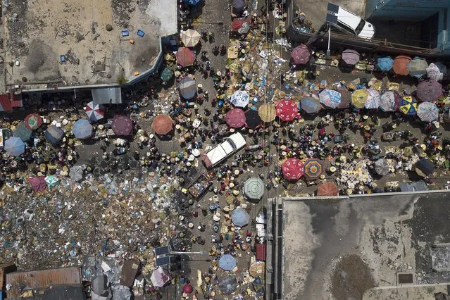 People shop at Petion-Ville market in Port-au-Prince, Haiti, Sunday, July 11, 2021, four days after the assassination of Haitian President Jovenel Moise. (Photo by Matias Delacroix/AP Photo)
