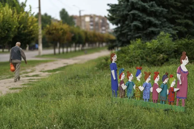 A wooden statue of children holding hands stands in an empty park in Kramatorsk, Donetsk region, eastern Ukraine, Friday, August 12, 2022. According to Ukraine's prosecutor general, 361 children have been killed in Ukraine since Russia's Feb. 24 invasion and 711 have been injured. (Photo by David Goldman/AP Photo)