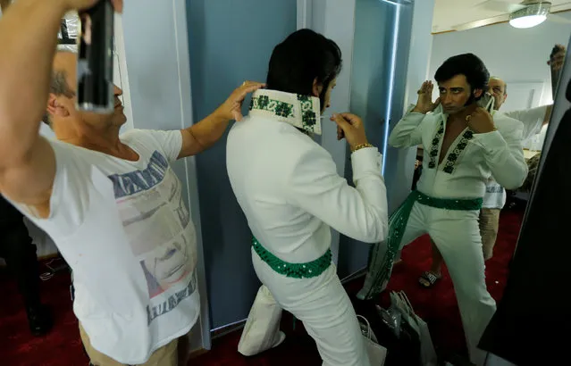 Elvis Presley tribute artist Sean Spiteri prepares in the mirror backstage before a singing contest at the 25th annual Parkes Elvis Festival in the rural Australian town of Parkes, west of Sydney, Australia January 13, 2017. (Photo by Jason Reed/Reuters)