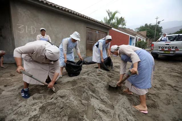 Nuns remove mud from outside a house after a landslide and flood in Chosica, Peru January 16, 2017. (Photo by Guadalupe Pardo/Reuters)