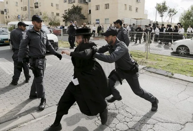 An Israeli policeman pushes an ultra-Orthodox Jewish protester after he tried to block a street in the town of Beit Shemesh, near Jerusalem April 16, 2015. Dozens of ultra-Orthodox Jewish protesters on Thursday demonstrated against construction at a site they believe contains ancient Jewish graves. (Photo by Ammar Awad/Reuters)