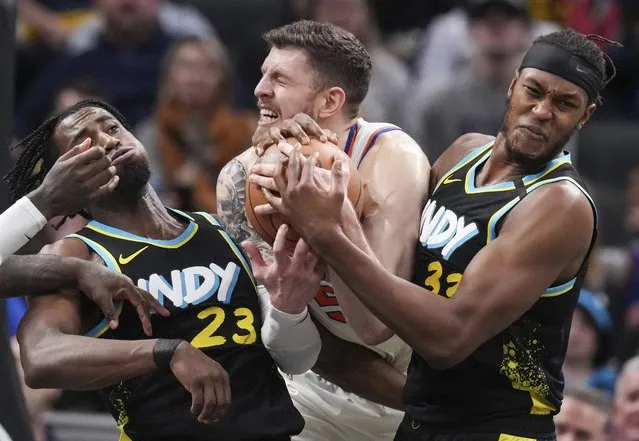 New York Knicks center Isaiah Hartenstein (55) wrestles for the ball against Indiana Pacers center Myles Turner (33) and forward Aaron Nesmith (23) during an NBA basketball game Saturday, December 30, 2023, in Indianapolis. (Photo by Grace Hollars/The Indianapolis Star via AP Photo)