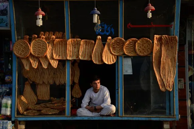 Afghan vendor Samim, 23, sits at his bakery as he waits to sell bread in Mazar-i-sharif on April 5, 2015. (Photo by Farshad Usyan/AFP Photo)