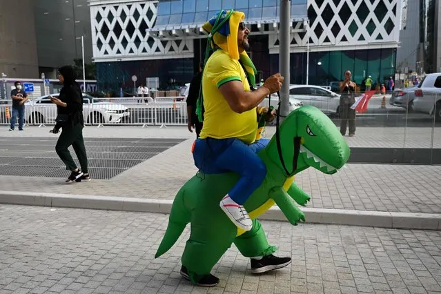 A Brazil fan dressed as a dinosaur walks around in Doha on November 19, 2022 ahead of the Qatar 2022 World Cup football tournament. (Photo by Patrick T. Fallon/AFP Photo)