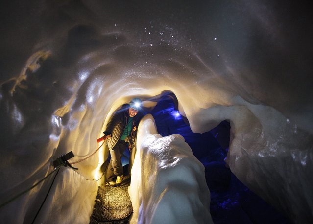 A tourist walks inside the Ice Palace glacier hollow at Hintertux glacier, located at around 3250 meters above sea level, in Zillertal, Austria, 02 March, 2016. The hollow's temperature remains constant at 0 degrees Celsius, in summer and winter alike, and is also used by the University of Innsbruck for scientific research projects. (Photo by Lisi Niesner/EPA)