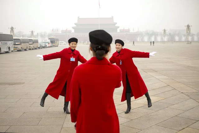 Hostesses, who facilitated the arrival of delegates on buses, pose for photos on Tiananmen Square near the Great Hall of the People in Beijing during a meeting ahead of Saturday's opening session of China's National People's Congress (NPC), Friday, March 4, 2016. (Photo by Mark Schiefelbein/AP Photo)