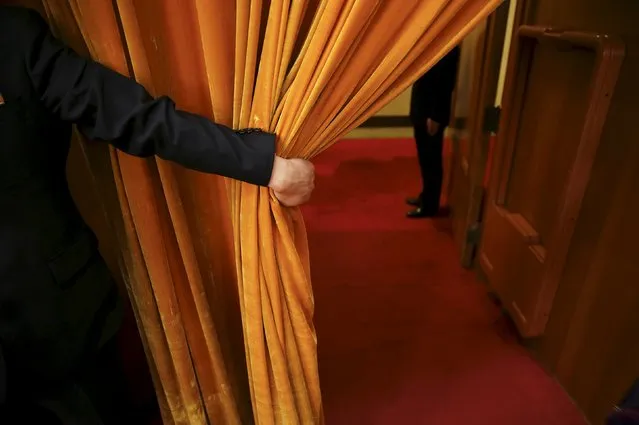 A security officer holds open a curtain during the opening session of the National People's Congress (NPC) at the Great Hall of the People, in Beijing, China, March 5, 2016. (Photo by Damir Sagolj/Reuters)