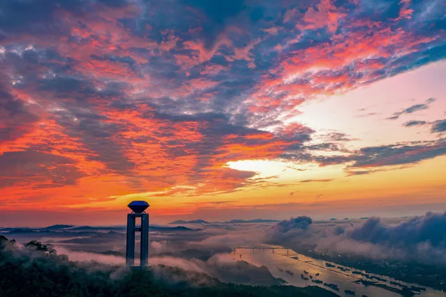 In the early morning of September 22, 2021, in the Baiyun Mountain Forest Park, Wuzhou City, Guangxi, the surrounding mountains are unobstructed, clouds and mists are lingering, and the gorgeous colorful glow is reflected by the sunrise. (Photo by Sipa Asia/Rex Features/Shutterstock)