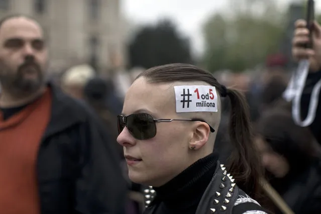 A woman wears a sticker reading “One in Five Million” in Serbian Latin letters, the slogan of protests against populist Serbian president Aleksandar Vucic, in Belgrade, Serbia, Saturday, April 13, 2019. Thousands of people protested against Serbia’s populist President Aleksandar Vucic on Saturday as riot police deployed inside the country’s parliament, saying they wanted to prevent the opposition from storming the building. (Photo by Marko Drobnjakovic/AP Photo)