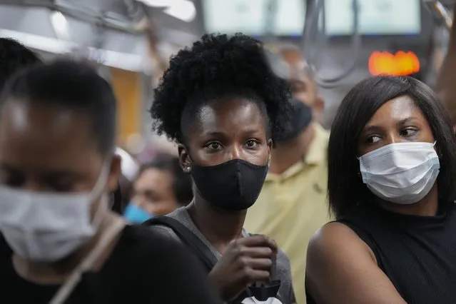Commuters wear protective face masks as they walk through a subway station, in Sao Paulo, Brazil, Wednesday, December 1, 2021, amid the COVID-19 pandemic. Brazil joined the widening circle of countries to report cases of the omicron variant. (Photo by Andre Penner/AP Photo)