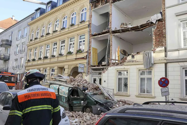 Debris lies on a car in front of a house whose facade has collapsed, presumably due to an explosion or a deflagration in Hamburg, Germany, Thursday, December 2, 2021. (Photo by Bodo Marks/dpa via AP Photo)