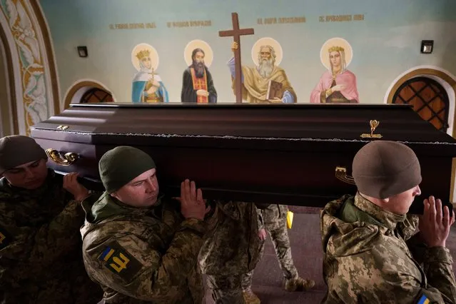 Ukrainian servicemen carry the coffin of a fallen soldier, at the St. Michael's Golden-Domed Monastery in Kyiv, Ukraine, Tuesday, March 26, 2024. (Photo by Vadim Ghirda/AP Photo)