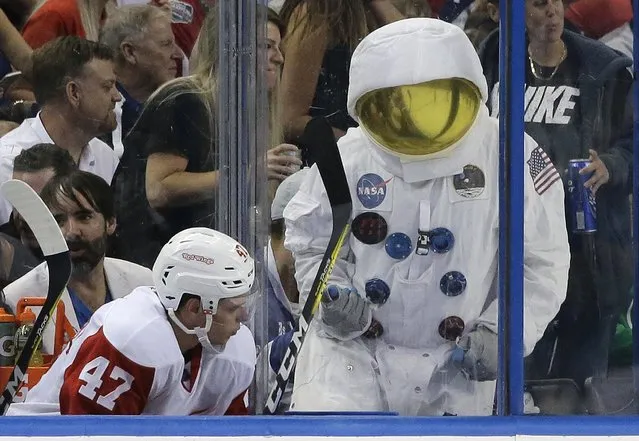 A Tampa Bay Lightning fan, wearing an astronaut suit, taunts Detroit Red Wings defenseman Alexei Marchenko (47), of Russia, during the third period of Game 1 in a first-round NHL hockey Stanley Cup playoff series Wednesday, April 13, 2016, in Tampa, Fla. (Photo by Chris O'Meara/AP Photo)