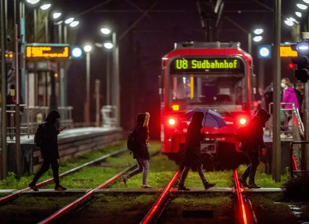 People rush to a train at a subway station in Frankfurt, Germany, Thursday, January 20, 2022 as the daily number of COVID-19 infections are rising again. (Photo by Michael Probst/AP Photo)