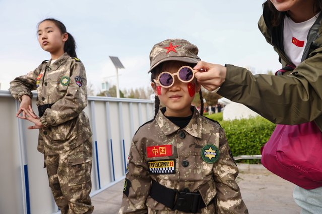 A girl in a military uniform poses for a photo after the see-off ceremony before the launch in Jiuquan, Gansu province, China, 25 April 2024. China's Shenzhou-18 manned spaceflight mission with three astronauts is the third manned spaceflight mission of China Space Station's development phase. The mission will last for about six months and the crew will carry out tasks such as installation, commissioning, maintenance, repair, and experiments in space. (Photo by Wu Hao/EPA/EFE)