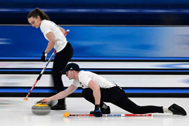 Britain's Jennifer Dodds and Britain's Bruce Mouat (R) curl the stone during the mixed doubles bronze medal game of the Beijing 2022 Winter Olympic Games curling competition between Sweden and Britain, at the National Aquatics Centre in Beijing on February 8, 2022. (Photo by Lillian Suwanrumpha/AFP Photo)