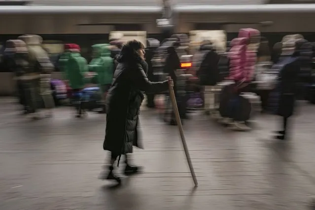 A woman walks on a platform as people crowd to board a Lviv-bound train in Kyiv, Ukraine, Monday, February 28, 2022. (Photo by Vadim Ghirda/AP Photo)