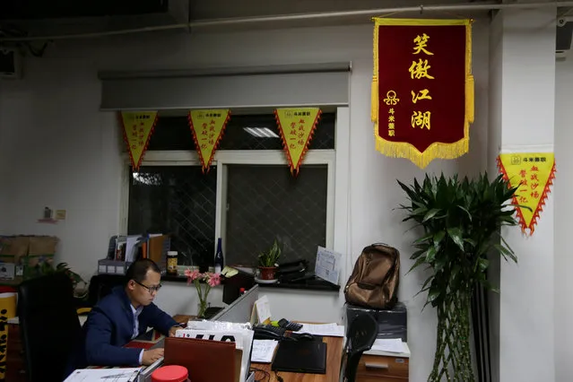 Liu Zhanyu, a client manager at DouMiYouPin, works around midnight in Beijing, China, April 20, 2016. (Photo by Jason Lee/Reuters)