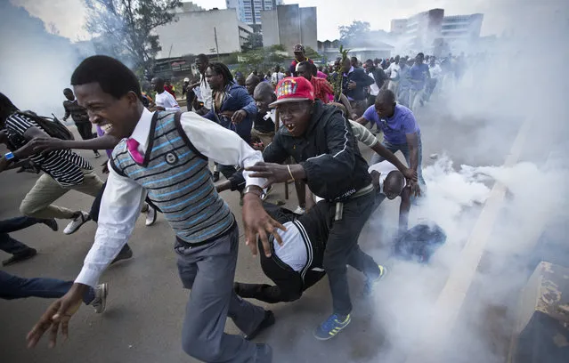 Opposition supporters flee from tear gas grenades fired by riot police, during a protest in downtown Nairobi, Kenya Monday, May 16, 2016. (Photo by Ben Curtis/AP Photo)