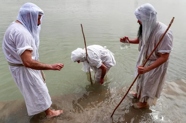 Adherents of the pre-Christian Sabaean faith, which considers the prophet Abraham as one of its founders, perform a ritual in the waters of the Tigris River in Iraq's capital Baghdad, on March 15, 2022. Eid al-Khalqeh is a five-day religious holiday celebrated by the Sabaeans, also known in English as Mandaeans, and is a monotheistic religion historically practised around the lower Euphrates and Tigris. The Sabaeans speak a distinct language, Mandaean, and their religious books are written in Sabaean script. (Photo by Ahmad Al-Rubaye/AFP Photo)