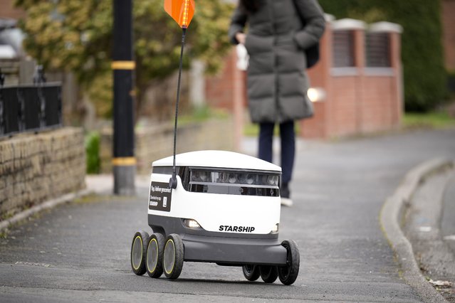 A Starship Technologies robotic vehicle delivers groceries to Co-op customers on March 15, 2023 in Manchester, England. The Co-op has been working with Starship Technologies to develop robots for local home delivery orders. The robots, small white packing cases on six wheels, use sensors and 12 cameras to enable them to navigate. They travel at walking speed, around 4mph, and their advanced technology enables them to manoeuvre around objects and people and wait until it is safe to cross the road. To deter thieves the little robot has a loud alarm which sounds if tampered with plus they are too heavy to pick up. (Photo by Christopher Furlong/Getty Images)