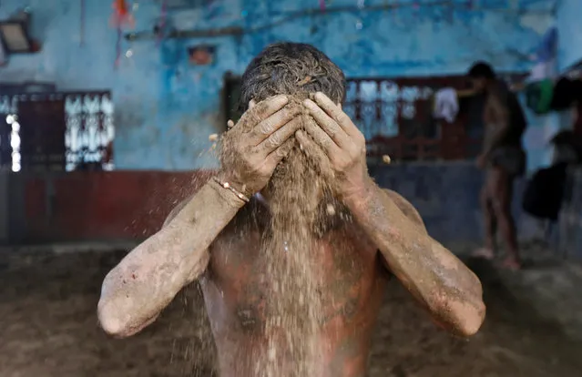 A wrestler applies mud to prevent slipping due to sweat, at a traditional training centre on the banks of the river Ganges ahead of the Bengal mud wrestling championships, in Kolkata, India May 17, 2016. (Photo by Rupak De Chowdhuri/Reuters)