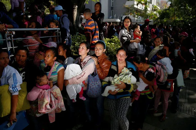 Women carrying babies queue as they try to buy diapers outside a pharmacy in Caracas, Venezuela March 18, 2017. (Photo by Carlos Garcia Rawlins/Reuters)