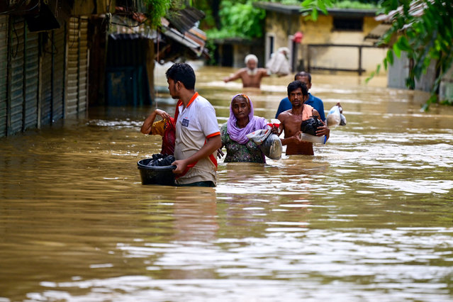 People wade through flood waters in Feni on August 23, 2024. Floods triggered by torrential rains have swamped a swath of low-lying Bangladesh, disaster officials said on August 22, adding to the new government's challenges after weeks of political turmoil. (Photo by Munir Uz Zaman/AFP Photo)