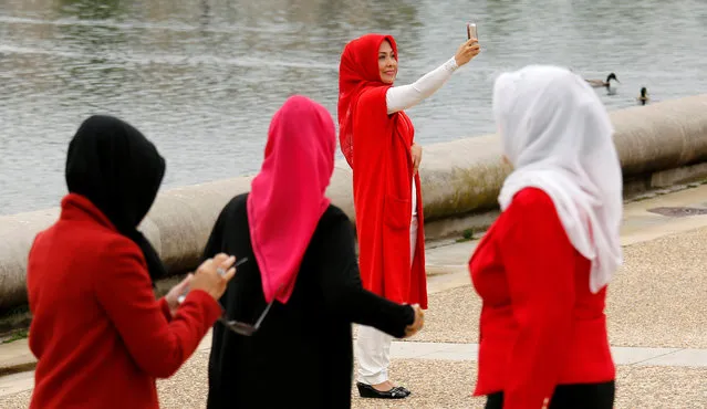 Tourists from Indonesia take photos in front of the Capitol Reflecting Pool in Washington, U.S., May 2, 2016. (Photo by Kevin Lamarque/Reuters)