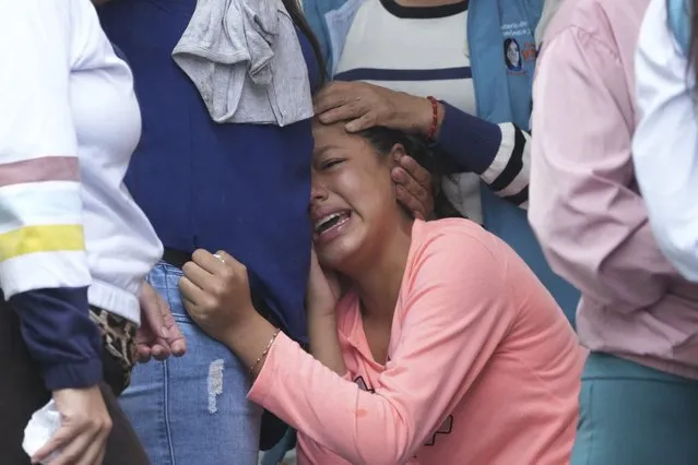 A woman cries outside the morgue where families wait for the bodies of dead inmates to be released after a deadly riot broke out in Bellavista jail in Santo Domingo de los Tsachilas, Ecuador, Tuesday, May 10, 2022. (Photo by Dolores Ochoa/AP Photo)