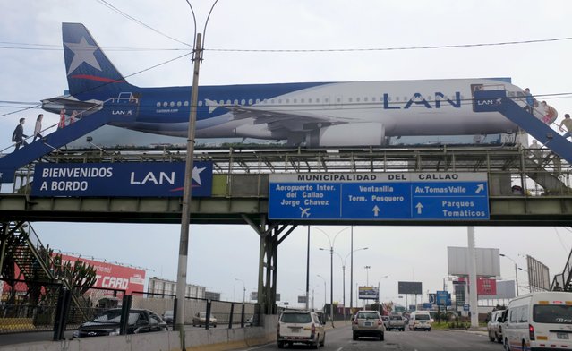 A billboard shows a plane of LAN Airlines, a member of LATAM Airlines Group, near the Jorge Chavez airport in Callao, Peru, August 10, 2015.  LATAM Airlines Group SA, Latin America's largest carrier, said on Thursday a recovery in its results would depend on a turnaround in the slumping Brazilian economy. (Photo by Mariana Bazo/Reuters)