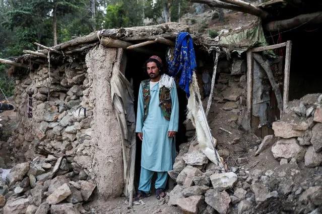 Barakatullah poses for a picture in front of his house that was damaged by an earthquake in Spolgin village, Spera district of Khost province, Afghanistan, June 26, 2022. (Photo by Ali Khara/Reuters)