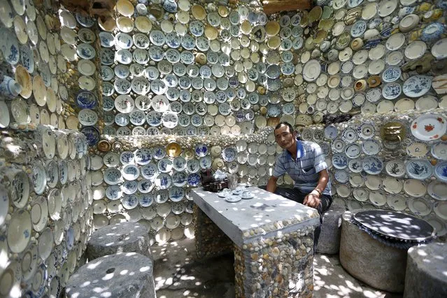 Nguyen Van Truong, 52, sits in his house covered by antique dishes, in Son Kieu village, Chan Hung commune, Vinh Phuc province, some 80 km from Hanoi, Vietnam, 06 August 2014. Nguyen Van Truong, a veteran, has been collecting antiques for over 20 years. Truong has started to attach all of his antiques to the walls and around his house in 2000.(Photo by Luong Thai Linh/EPA)