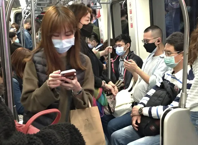 People wear face masks to protect against the spread of the coronavirus on MRT in Taipei, Taiwan, Saturday, March 7, 2020. (Photo by Chiang Ying-ying/AP Photo)