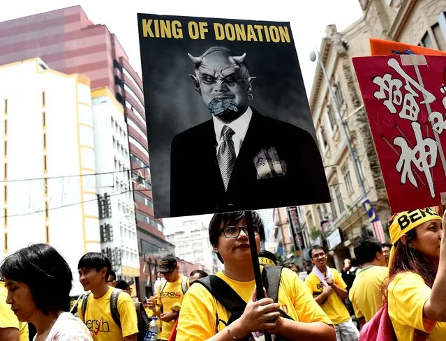 A protestor holds a placard criticising Malaysian Prime Minister Najib Razak on the second day of the anti-government rally near the Independence square in Kuala Lumpur on August 30, 2015. Crowds of yellow-clad Malaysians demanding the resignation of Prime Minister Najib Razak over a corruption scandal converged on central Kuala Lumpur again on August 30, a day after tens of thousands paralysed the capital in a boisterous yet peaceful demonstration. (Photo by Manan Vatsyayana/AFP Photo)