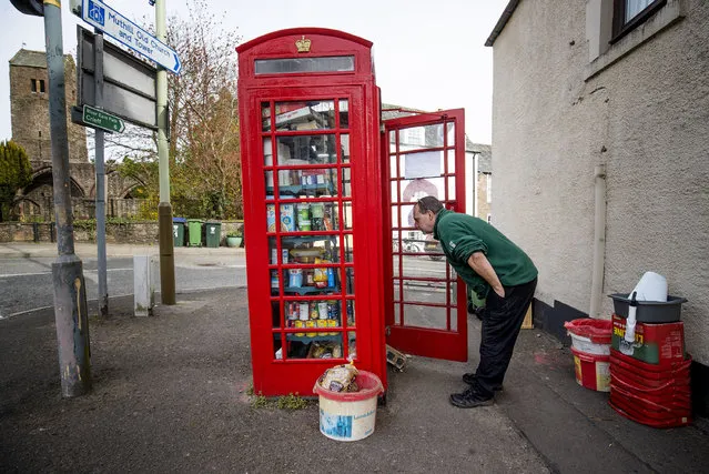 Local residents use the community food larder in Muthill, near Crieff in Perthshire on April 14, 2020, which was set up using the old village phone box as a food collection and donation point as the UK continues in lockdown to help curb the spread of the coronavirus. (Photo by Jane Barlow/PA Images via Getty Images)