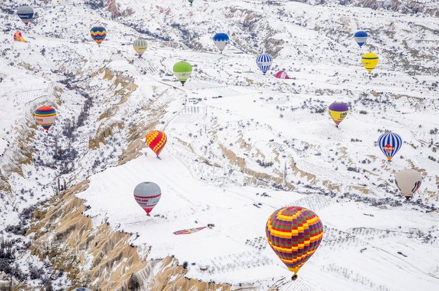 Hot air balloons fill the sky above a winter wonderland after heavy snowfall in Cappadocia, Turkey in the first decade of December 2024. (Photo by Seyit Konyali/Solent News & Photo Agency)