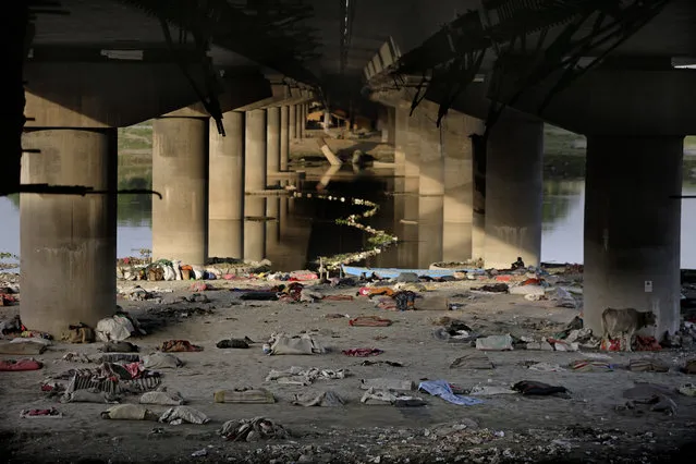 Beddings and other belongings of Indian migrant laborers and homeless people lie scattered after they were evicted from the banks of Yamuna River where they were squatting during lockdown in New Delhi, India, Wednesday, April 15, 2020. (Photo by Altaf Qadri/AP Photo)