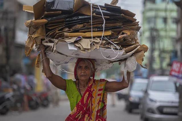 An elderly Indian woman carries recyclable carton boxes on her head during nationwide lockdown in Gauhati, India, Thursday, April 23, 2020. As governments around the world try to slow the spread of the coronavirus, India has launched one of the most draconian social experiments in history, locking down its entire population, including an estimated 176 million people who struggle to survive on $1.90 a day or less. (Photo by Anupam Nath/AP Photo)