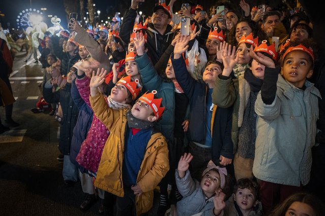 Children greet one of the three wise men as they attend the traditional “Cabalgata de Reyes” parade in Barcelona, Spain, Sunday, January 5, 2025, as part of the festivities marking the Catholic feast of Epiphany. (Photo by Emilio Morenatti/AP Photo)