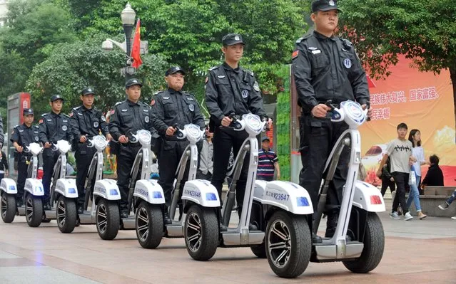 Chinese urban enforcement officers ride self-balancing scooters to patrol street on the Hanjiang Road on October 10, 2017 in Wuhan, Hubei Province of China. Considering large number of pedestrians and their safety on the Hanjiang Road, urban enforcement officers patrol with self-balancing scooters instead of electric quadricycles. (Photo by VCG/VCG via Getty Images)