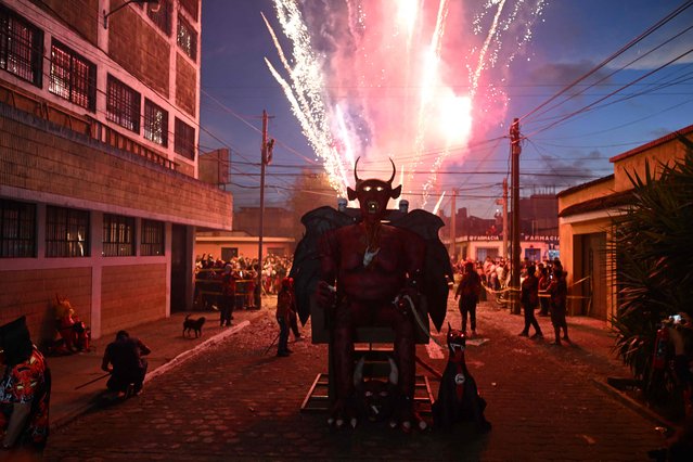 Fireworks explode above a devil's figure before being set ablaze during celebrations in honor of the Virgin of the Immaculate Conception on December 7, 2023, in Guatemala City. The event marks the beginning of the Christmas season in Guatemala. (Photo by Johan Ordonez/AFP Photo)