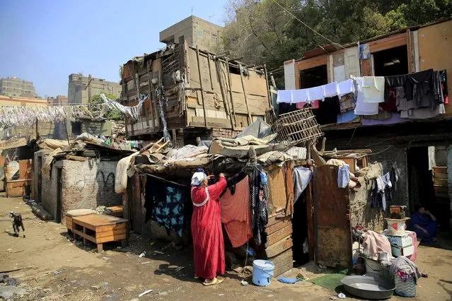 A woman washes her clothes in the Eshash el-Sudan slum in the Dokki neighbourhood of Giza, south of Cairo, Egypt September 2, 2015. (Photo by Amr Abdallah Dalsh/Reuters)