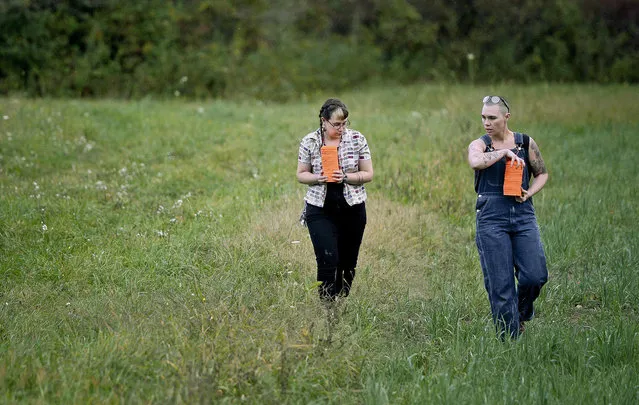 In this October. 8, 2017, photo, Zora Gussow, left, and Emily Lynch collect unbroken clay targets from after a shooting session of the Trigger Warning Queer & Trans Gun Club in Victor, N.Y. The gun club members stress they are about empowerment and self-defense, not offense. They say it also gives them a sense of community, even if it comes on a firing line in the middle of farm country. But some veteran activists say they're concerned that this will add to an unnecessary arms race and eventually cause more danger. (Photo by Adrian Kraus/AP Photo)