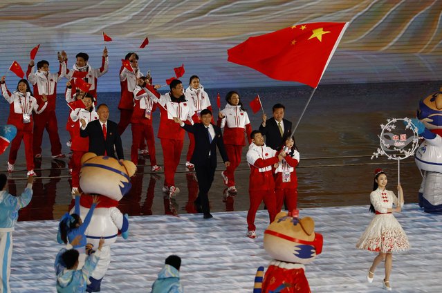 Flag bearers Ning Zhongyan and Liu Mengting of China lead their contingent during the parade of athletes at the opening ceremony of the 9th Asian Winter Games in Harbin, China, Friday, February 7, 2025. (Photo by Issei Kato/Pool Photo via AP Photo)